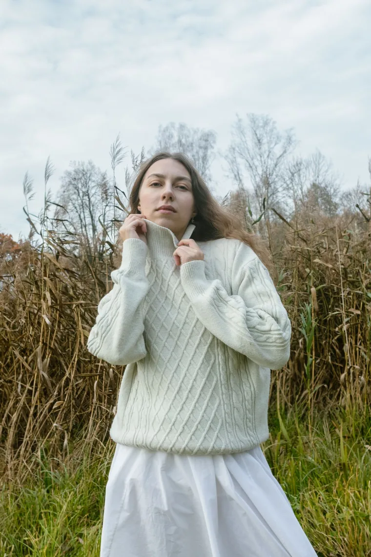 Frau in cremefarbenem Cable-Knit-Pullover